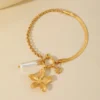 PULSERA DORADA RÍGIDA CON DIJE FLOR