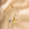 PULSERA CON PERLAS BLANCAS Y DIJE DORADO